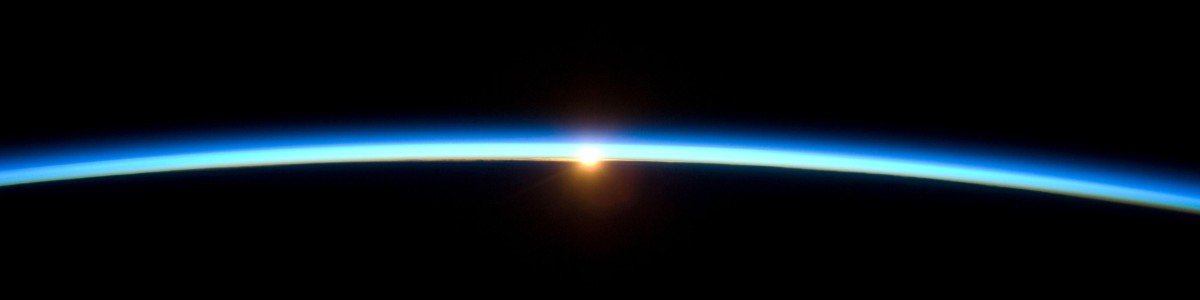 A thin, glowing band of Earth's atmosphere seen at the horizon from orbit